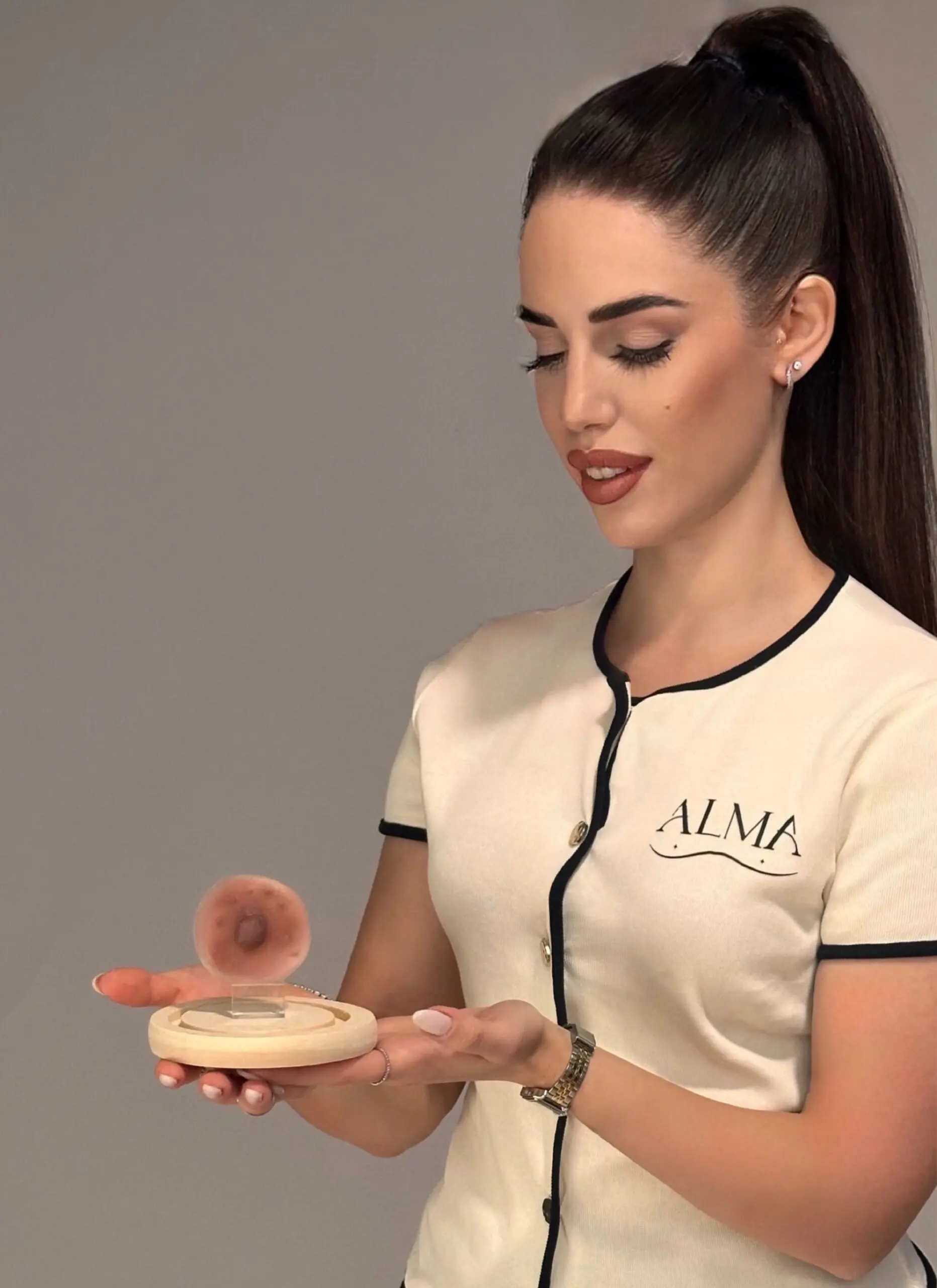 Guendalina Guzzo sosteniendo una prótesis de areola ALMA elaborada en silicona médica de platino, destacando su naturaleza biocompatible y artesanal - Alma Design Care. Barcelona y Costa del Sol.